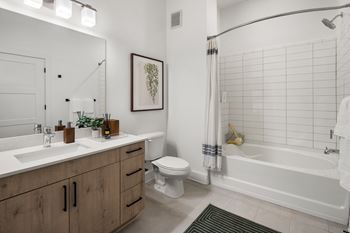 A bathroom with a white tub, sink, and toilet.